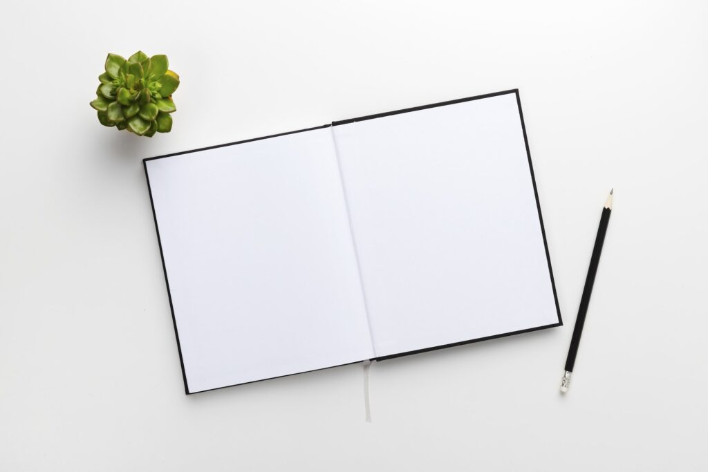 Top view of contemporary white office desk with book and pencil