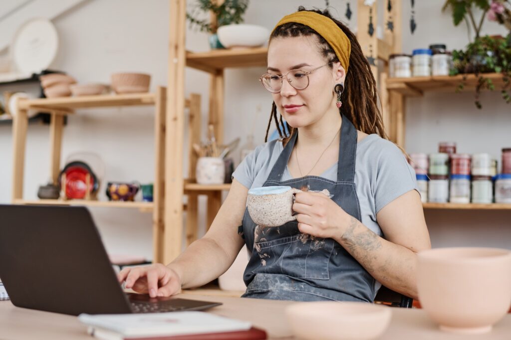 Young female freelancer or owner of small business sitting in front of laptop